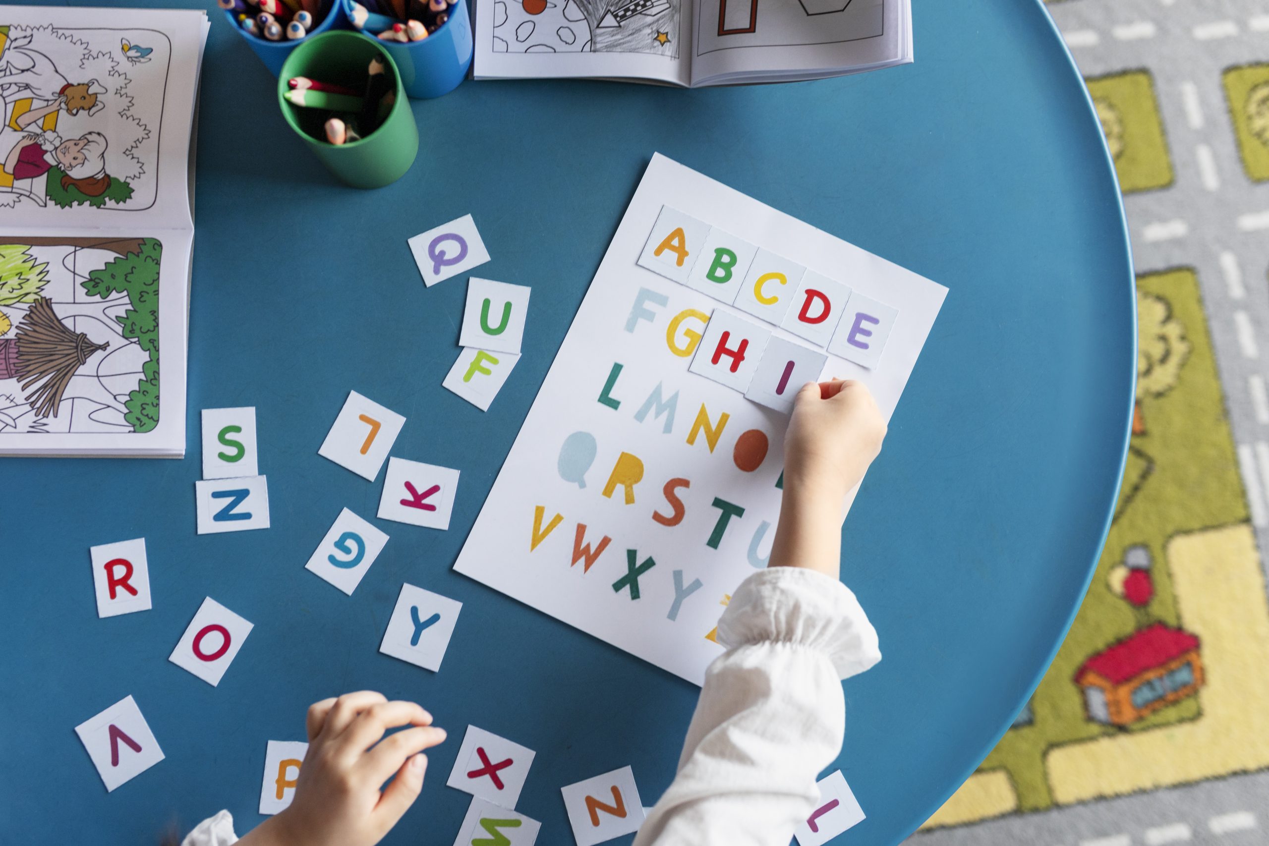 top-view-kid-learning-letters-kindergarten